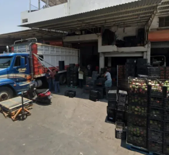 Fachada del local de Gomqui en el Mercado de Abastos de Guadalajara con cajas de mango